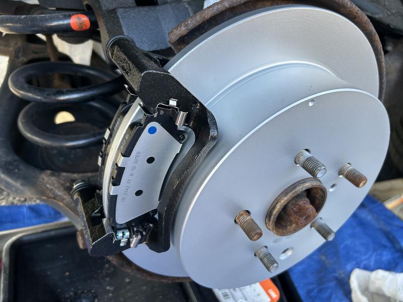 New brake pads and rotor installed on vehicle