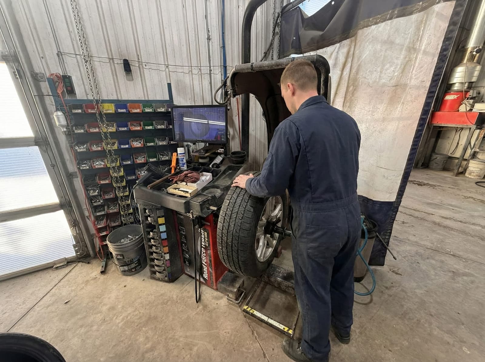 Technician balancing tire on Hunter Road Force balancer